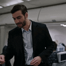 a man in a suit and blue shirt is standing in a plane