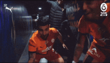 a group of soccer players are dancing in a hallway with a youtube logo in the background