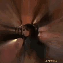 a blurry photo of a woman with the name li almeida on the bottom right