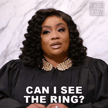 a woman in a judge 's robe is asking " can i see the ring "