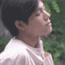 a close up of a man 's face with his eyes closed and a blurred background .
