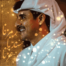 a man wearing a white head scarf and a white shirt is smiling