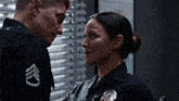 a man and a woman are looking at each other and the man has a badge that says sgt