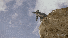 a picture of a dragon flying over a cliff with the word oneg in the corner