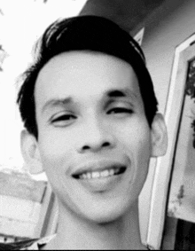 a black and white photo of a smiling man