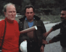 a man in a red sweater is being escorted by two men