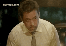 a man wearing a white shirt and tie is sitting at a table .