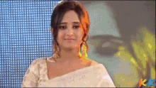 a woman stands in front of a screen that says kk