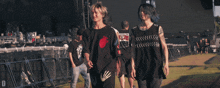 a group of people walking in a field with one wearing a shirt that says ' skeleton ' on it