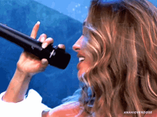 a close up of a woman singing into a microphone with anahioverdose written on the bottom