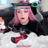a girl with pink hair is playing a video game with the name willowleef on the bottom