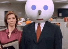 a man in a suit has a jack in the box face on his head