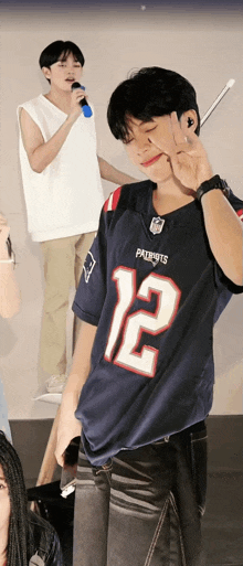 a man wearing a patriots jersey with the number 12