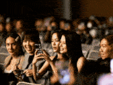 a group of women sitting in a dark room with the word filmation visible