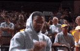 a man in a white hoodie stands in a crowd with a sign that says focus execute