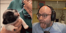 a man wearing headphones holds a puppy next to a picture of a puppy