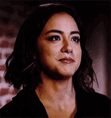 a close up of a woman 's face with a serious expression .