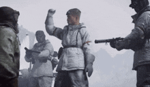 a man in a white coat with a red x on it stands in front of two other men holding guns
