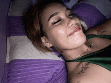 a woman laying on a purple and white striped blanket