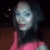 a woman in a pink top is looking at the camera