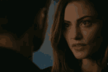 a man and a woman are looking at each other in a dark room