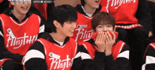 a group of young men wearing red jerseys with the word flying on them are laughing