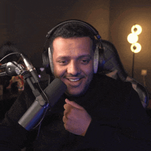 a man wearing headphones and a microphone is making a funny face