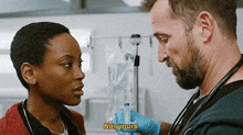 a man is holding a syringe next to a woman who is talking to him .