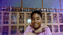 a boy in front of a wall of trophies
