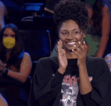 a woman wearing a black shirt with a dragon on it is clapping