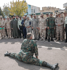 a man in a military uniform is doing a split in front of a group of men