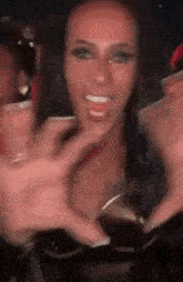 a woman is holding a cup in front of her face and smiling while a group of people toast her .
