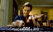 a man is typing on a keyboard with the words `` working late '' written below him .