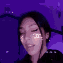 a chanel logo is projected on the face of a girl