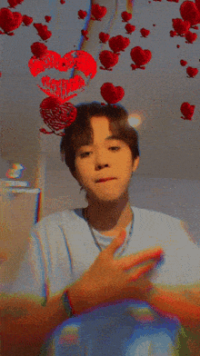 a young man is giving a peace sign while holding a red heart