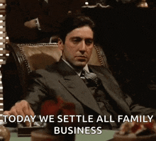 a man in a suit and tie is sitting at a table saying today we settle all family business