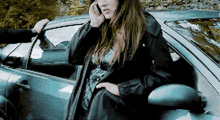 a woman in a black jacket is talking on a cell phone