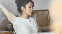 a woman wearing a white t-shirt that says maxim stretches her arms