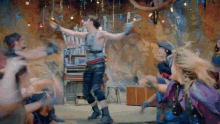 a group of people are dancing in a room with a man dancing in the middle