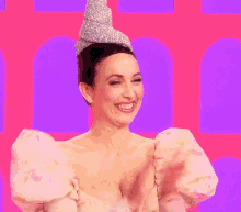 a woman wearing a crown and a floral dress is smiling