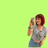a girl with red hair is taking a picture of herself with a phone
