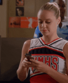 a cheerleader wearing a red white and black uniform with the word mhs on it