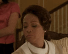 a close up of a woman sitting in a chair with her eyes closed