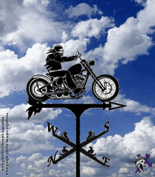 a weather vane with a picture of a man riding a motorcycle on it