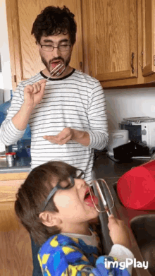 a man and a boy are playing with a mixer in a kitchen with imgplay written on the bottom right
