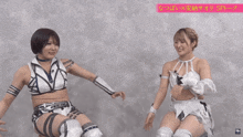 two female wrestlers are sitting next to each other and one of them is wearing a white top with the word x on it