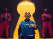 a woman wearing a blue vest with the number 044 stands in front of a keyhole