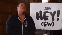 a man stands in front of a sign that says hey ew