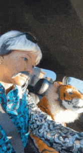 a woman sitting in a car with a stuffed tiger