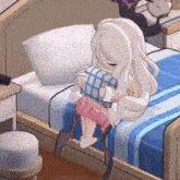 a little girl is sitting on a bed holding a pillow .